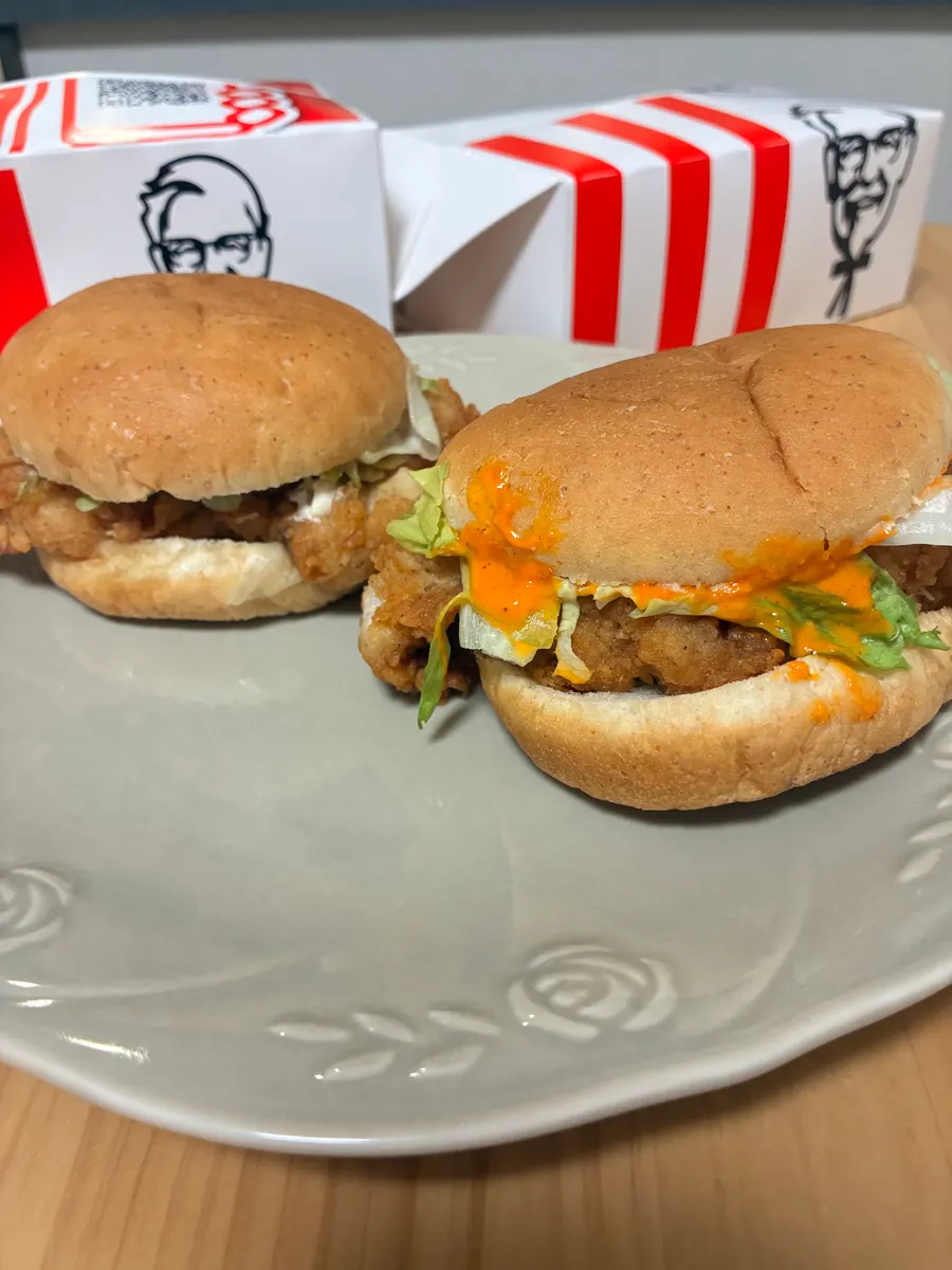 皿に並んだ通常版とレッドホットソースのチキンバーガー