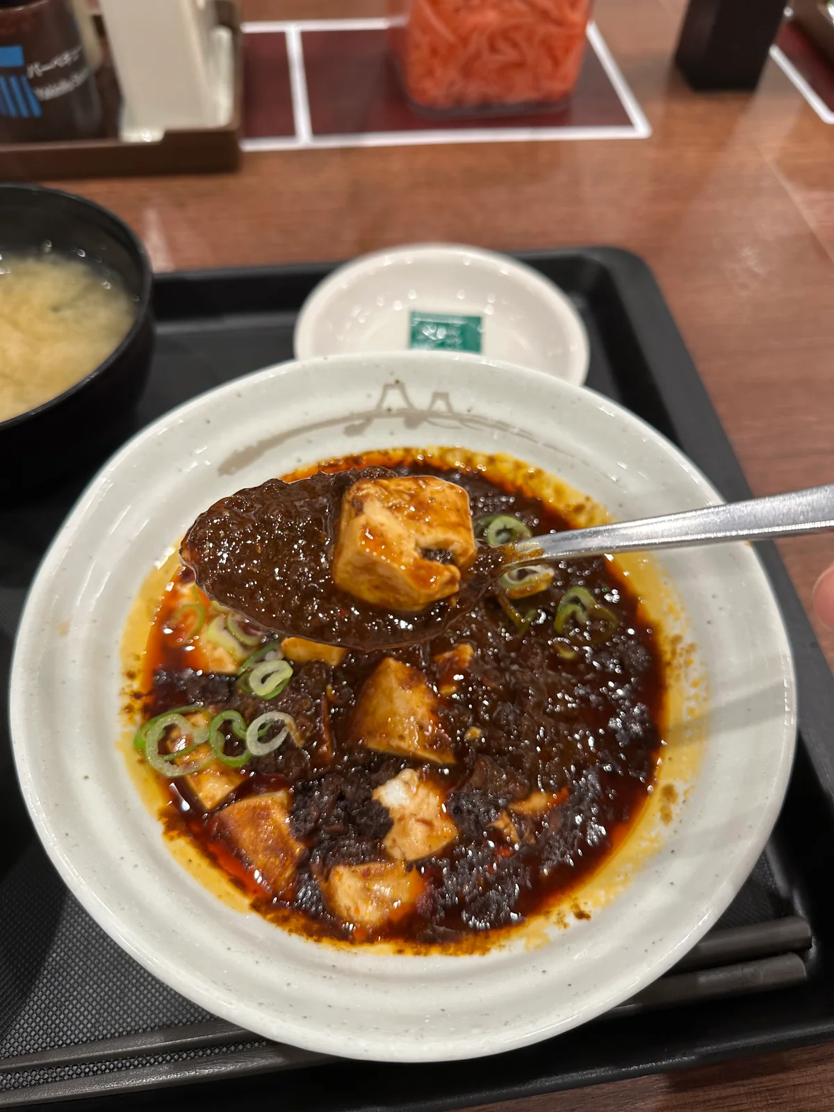 スプーンですくった松屋の黒麻婆豆腐。豆腐、ひき肉、青ねぎが見える