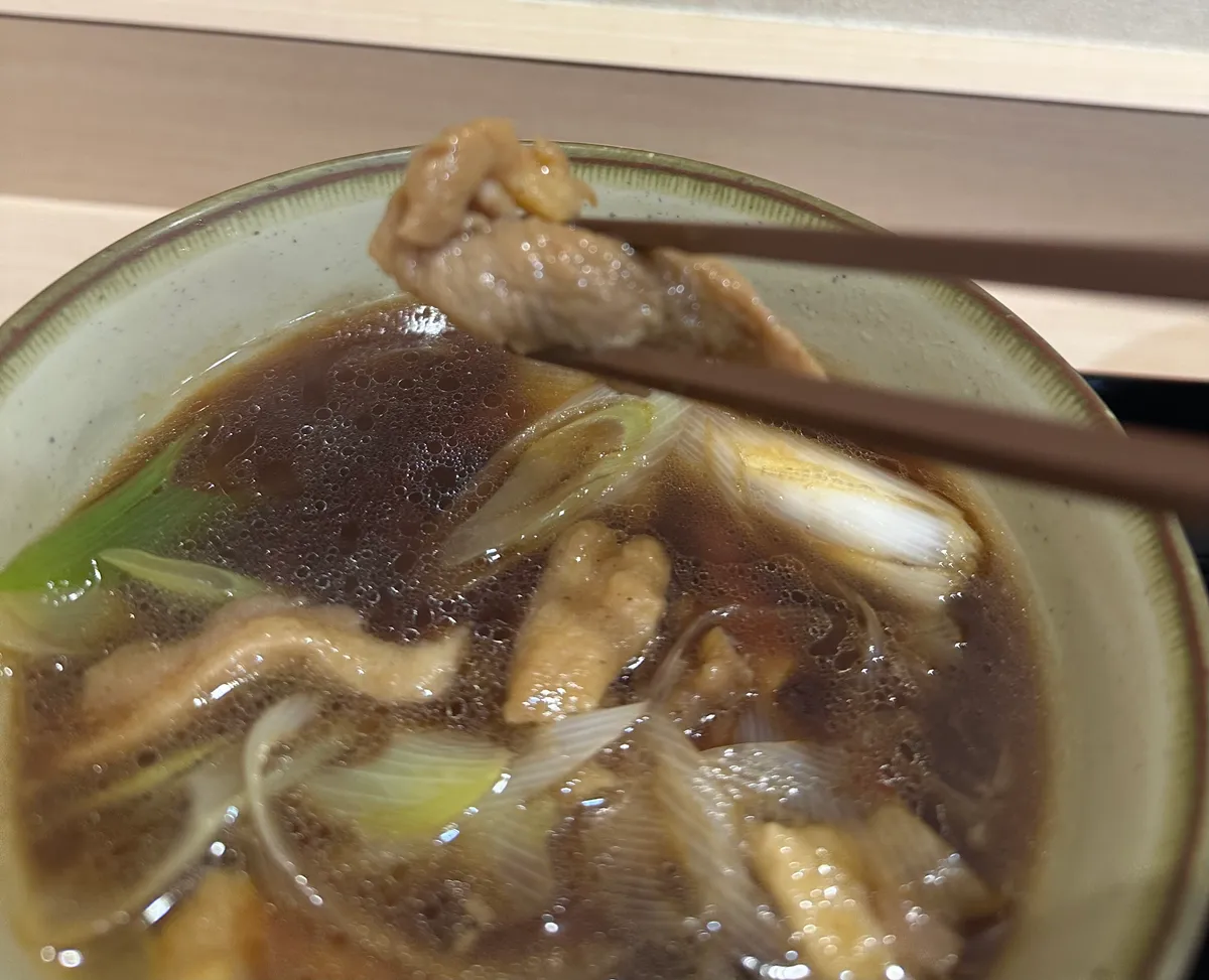 箸で持ち上げたゴロゴロ鴨せいろの鴨肉
